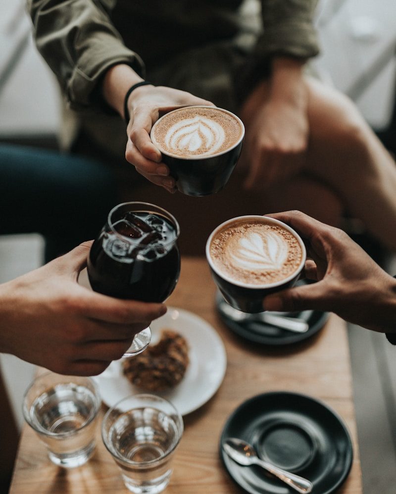 three person holding mug and glass with beverage inside